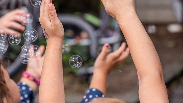 Kinder spielen mit Seifenblasen