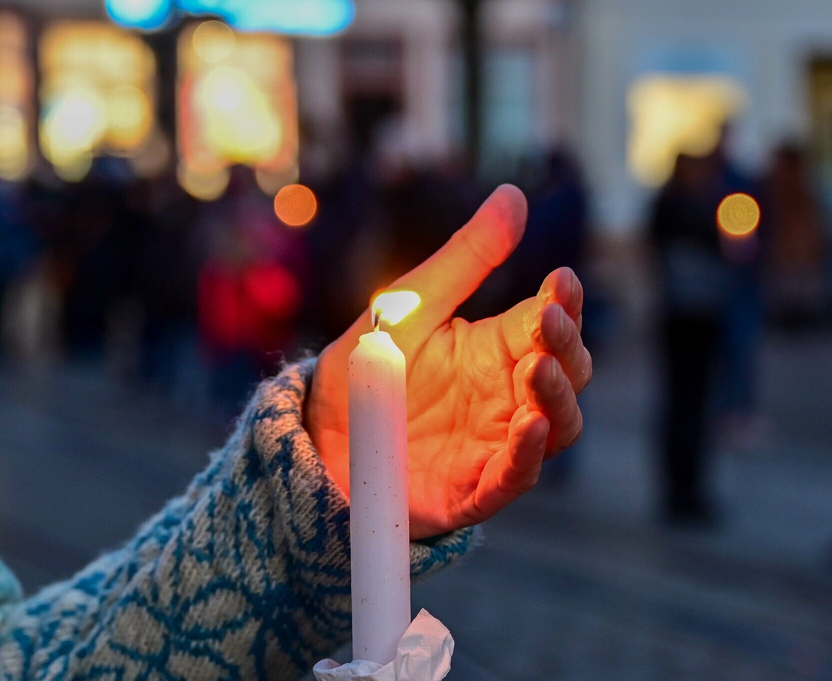 Bei der Mahnwache "Karlsruhe steht zusammen: Solidarität mit der Ukraine!" am 6. März auf dem Marktplatz wird eine brennende Kerze hochgehalten.