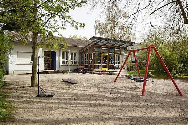 Kita Dornwaldsiedlung Gebäudeansicht Kindertagesstätte Dornwaldsiedlungmit Spielbereich im Vordergrund