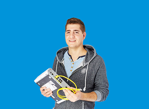 Mann mit Router in der Hand vor blauem Hintergrund