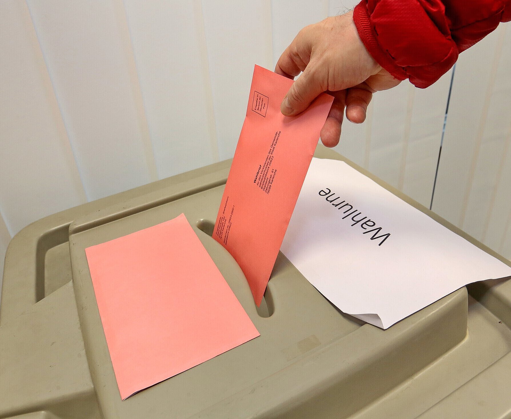 Briefwahlbüro Roter Wahlbrief wird in Wahlurne geworfen
