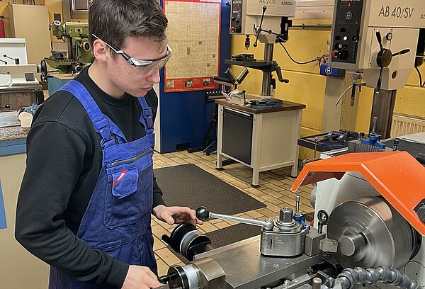 Junger Mann an der Drehmaschine