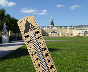 Hitze – was tun? Thermometer mit Anzeige von 34°C vor dem Karlsruher Schloss