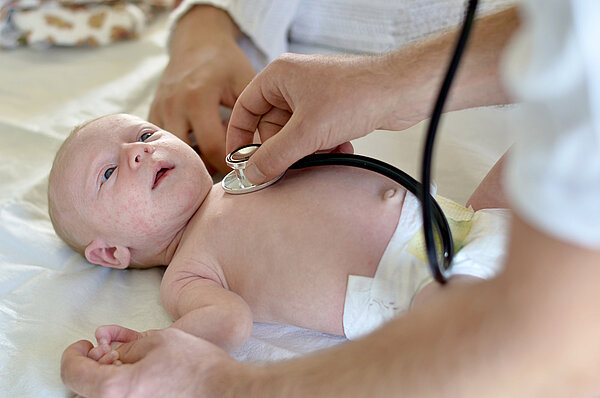 Baby wird mit einem Stethoskop untersucht