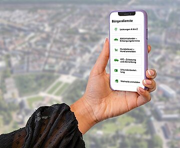 Bürgerdienste Das Bild zeigt ein Smartphone-Display mit einer Auswahl an eServices, im Hintergrund eine Panoramaansicht von Karlsruhe.