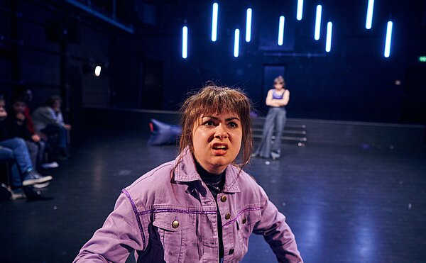 constantcraving Szene aus dem Theaterstück, junge Frau in lila Jacke