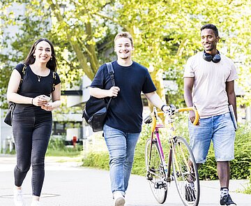 Studierende schlendern über den Campus Studierende schlendern über den Campus