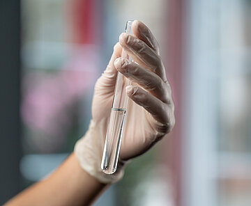 Abwassermonitoring Hand mit Reagenzglas