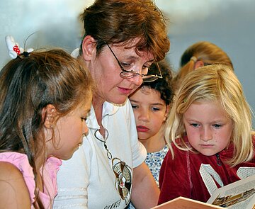 Ehrenamtliche Lesepatin Ehrenamtliche Lesepatin liest Kindern vor.