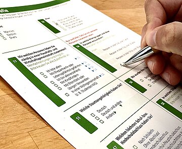 Umfrage Person beim Ausfüllen eines Papierfragebogens