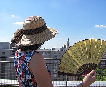 Sonnenhut und Fächer Frau von hinten mit Sonnenhut und Fächer