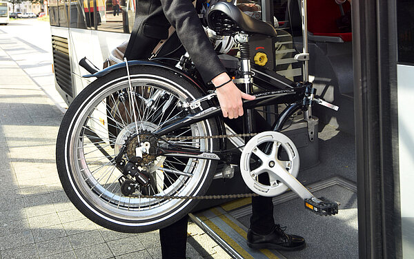 Fahrradmitnahme Das Foto zeigt einen Fahrgast, der ein Fahrrad mit in den Bus nimmt.
