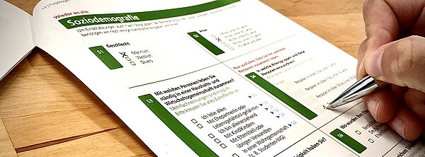 Umfrage Person beim Ausfüllen eines Papierfragebogens
