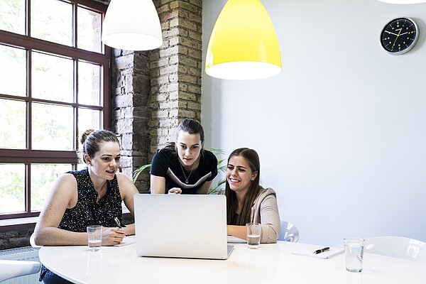 Studierende lernen gemeinsam Drei Studentinnen arbeiten im Team an einem Laptop.