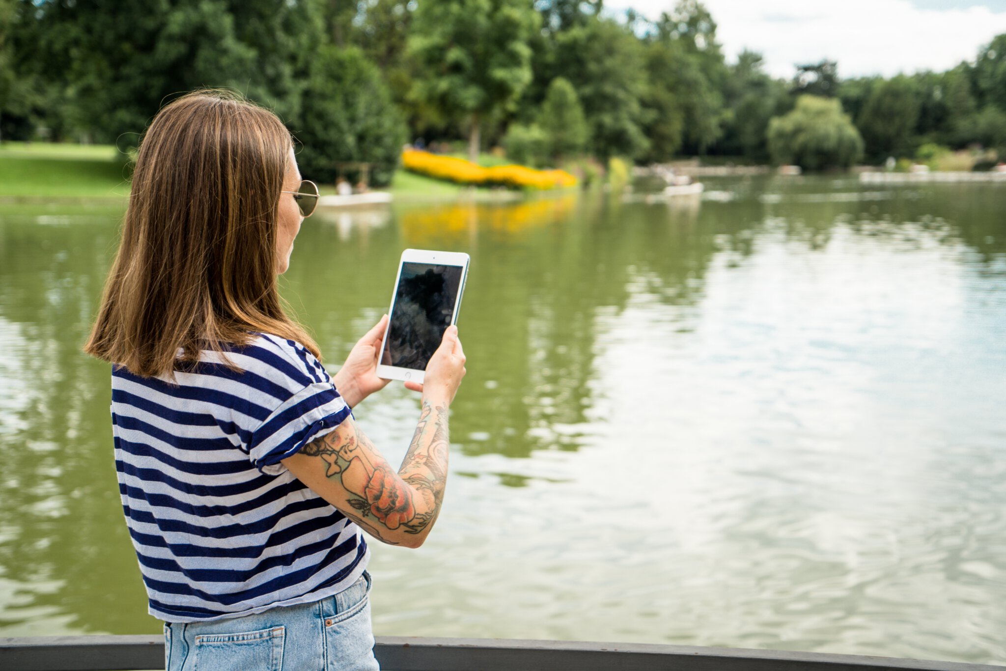 KA-WLAN 2 Eine junge Frau fotografiert den vor ihr liegenden See mit ihrem Tablet.