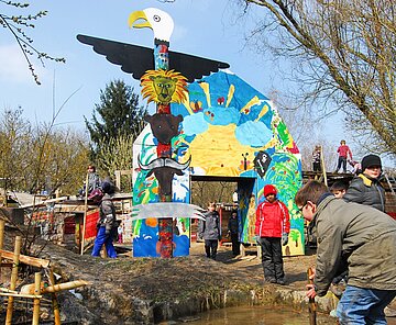 Das Bild zeigt spielende Kinder an einer Wasserstelle auf dem Aktivspielplatz.