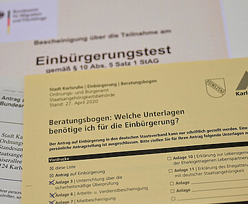 Das Bild zeigt mehrere Dokumente, die für eine Einbürgerung benötigt werden.