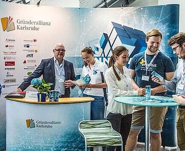 In diesem Bild ist zu sehen ein Messestand der Gründerallianz auf der IT-Trans Messe in der dm-Arena in Karlsruhe. 