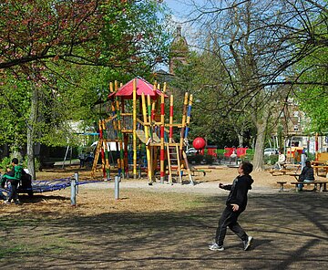 Junge mit Ball auf einem Spielplatz