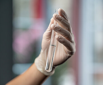 Hand mit Reagenzglas