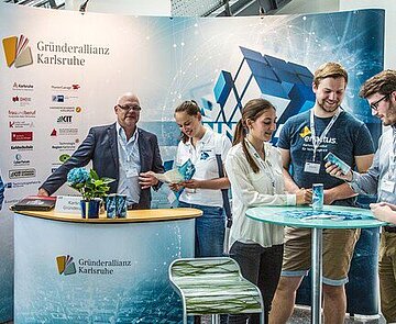 In diesem Bild ist zu sehen ein Messestand der Gründerallianz auf der IT-Trans Messe in der dm-Arena in Karlsruhe. 