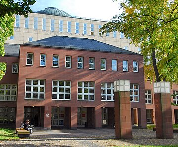 Der Eingang des Badischen Landesbibliothek eingerahmt von Bäumen.