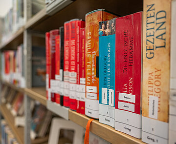 Bunte Bücher in einem Bücherregal in einer Bibliothek