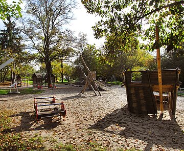 Eine Wippe, eine Reifenschaukel und andere Geräte auf einem Spielplatz