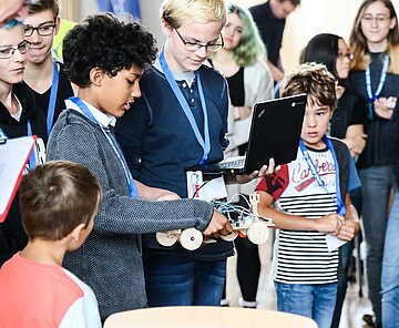 Zwei Schüler präsentieren ihre Erfindung ihren gebannten Zuhörer:innen