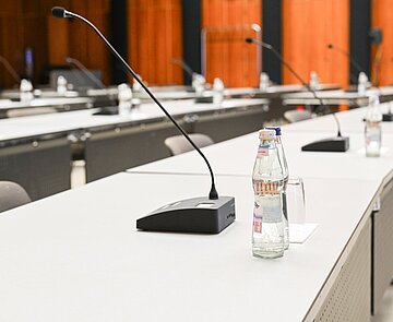 Einzelne Tische mit Mikrofonen im Bürgersaal.