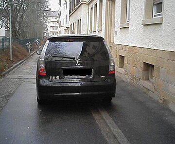 Das Bild zeigt ein falsch geparktes Auto. Tatbestand: Parken an enger und unüber­sicht­li­cher Stelle