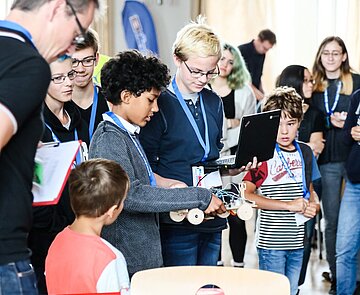 Zwei Schüler präsentieren ihre Erfindung ihren gebannten Zuhörer:innen
