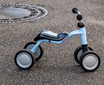 Blaues Dreirad steht auf Straße