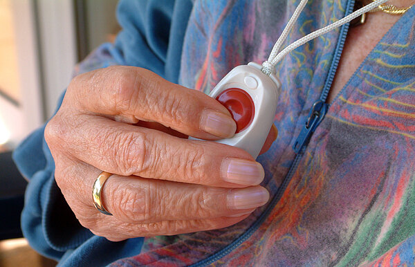 Nahaufnahme einer Hand, die Notruf drückt.