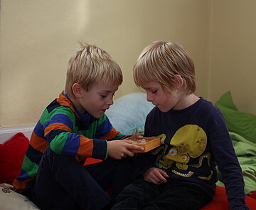 Zwei Grundschulkinder spielen in der Sitzecke