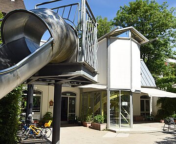 Kindertagesstätte Lußstraße Gebäudeansicht mit Rutsche im Vordergrund