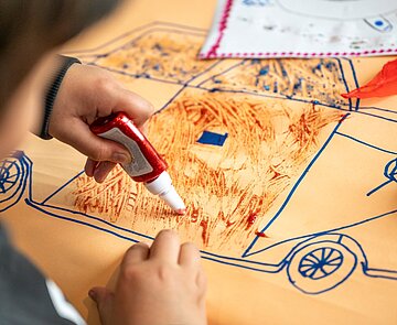 Kind arbeitet mit Tonpapier