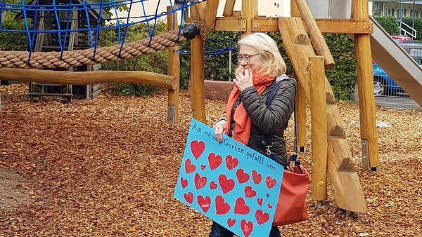 Kinder übergeben Dankesplakat für neuen Spielplatz