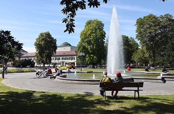 Das Bild zeigt den Friedrichsplatz mit Sitzmglichkeiten und Fontäne.