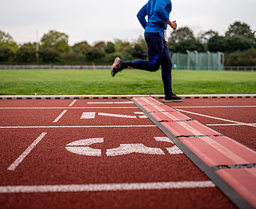 Sportler läuft auf Rennbahn