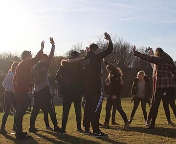 Mehrere Jugendliche stehen auf einer Wiese