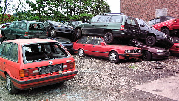 Das Bild zeigt gestapelte Schrottautos.