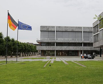 Das Bundesverfassungsgericht mit der Europa- und der Deutschlandflagge im Vordergrund.