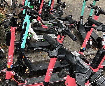 Das Bild zeigt verschiedene E-Scooter auf einer Abstellfläche.