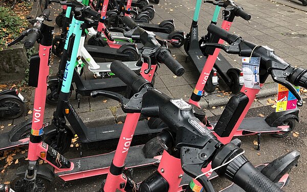 Das Bild zeigt verschiedene E-Scooter auf einer Abstellfläche.