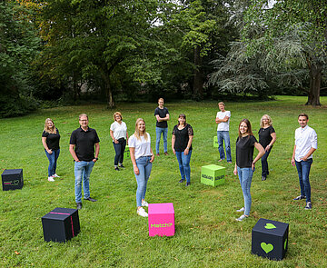 Mitarbeiter stehen auf der Wiese