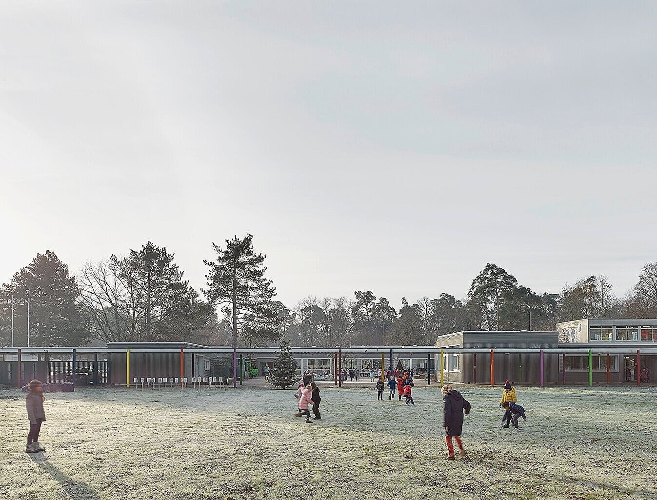 Zu sehen ist der Schulhof mit spielenden Kindern sowie Teile der Fassade.