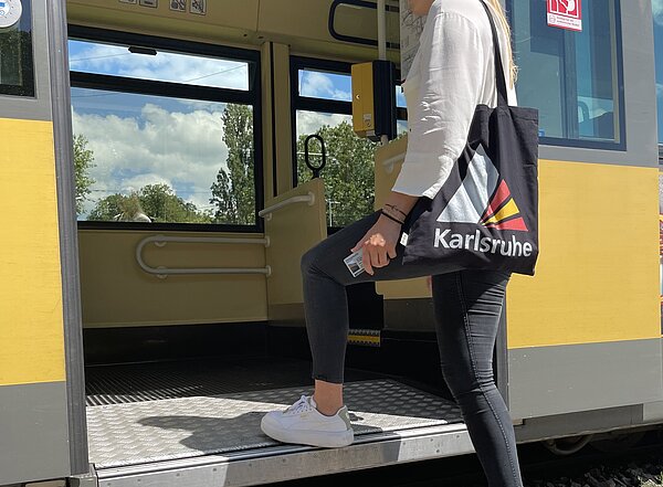 Mädchen mit Jutetasche steigt in eine Bahn