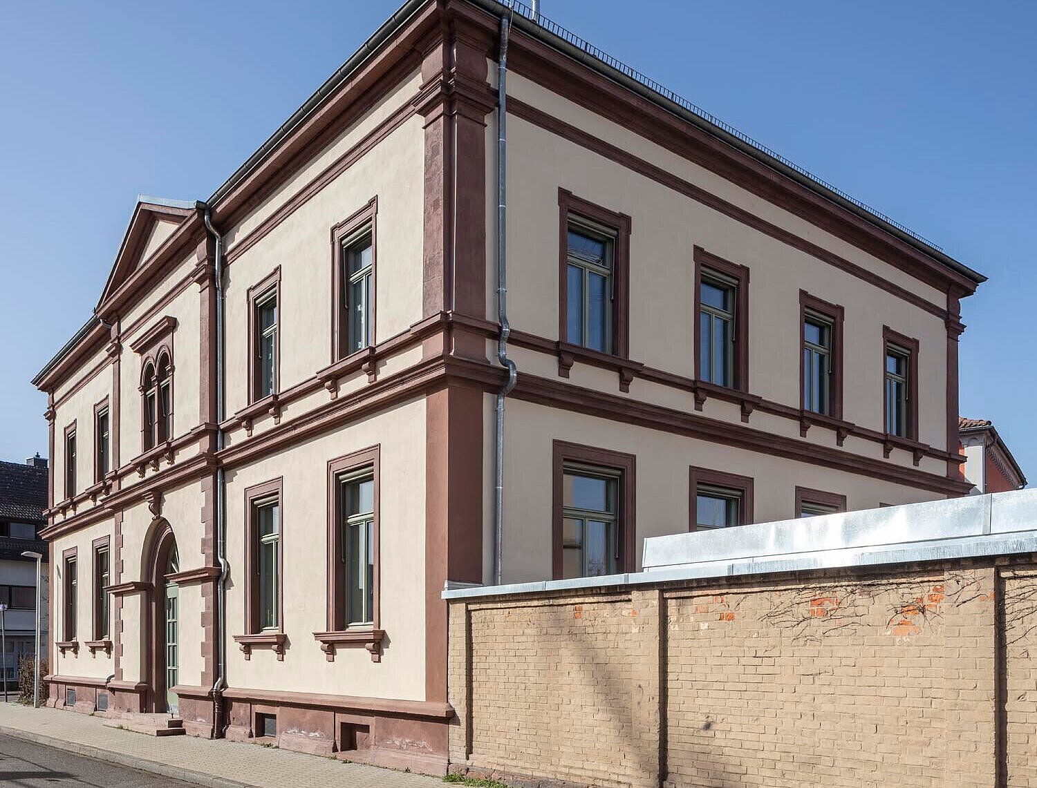 Südwestansicht der sanierten Sandsteinfassade mit neuen Fenstern und Sonnenschutzmarkisen