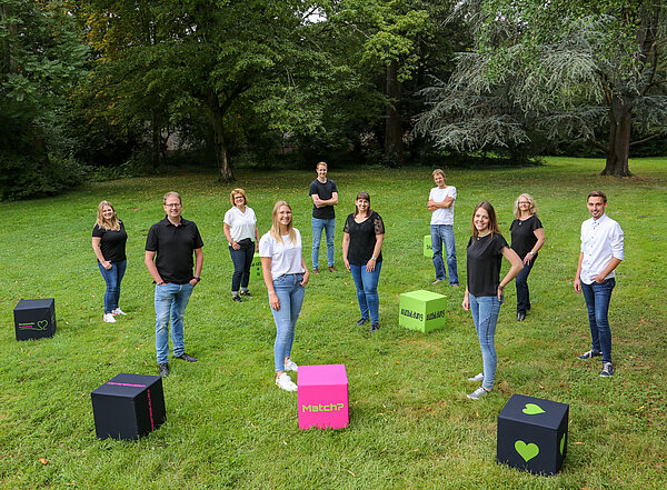 Mitarbeiter stehen auf der Wiese